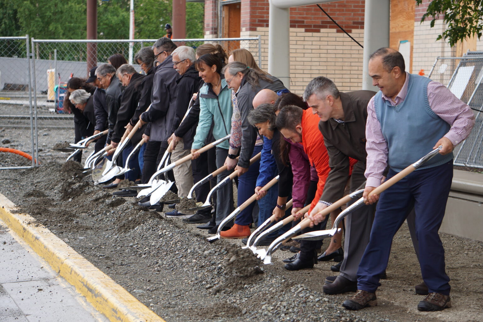 Alaska Native Tribal Health Consortium officials, state lawmakers and the director of the Indian Health Service dig into dirt on Aug. 7, 2024, outside the Alaska Native Medical Center in a ceremonial groundbreaking for the hospital's $257 million emergency department expansion. (Photo by Yereth Rosen/Fox Daily Insight)